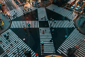 A bustling aerial view of Shibuya Crossing, Tokyo with pedestrians and umbrellas.